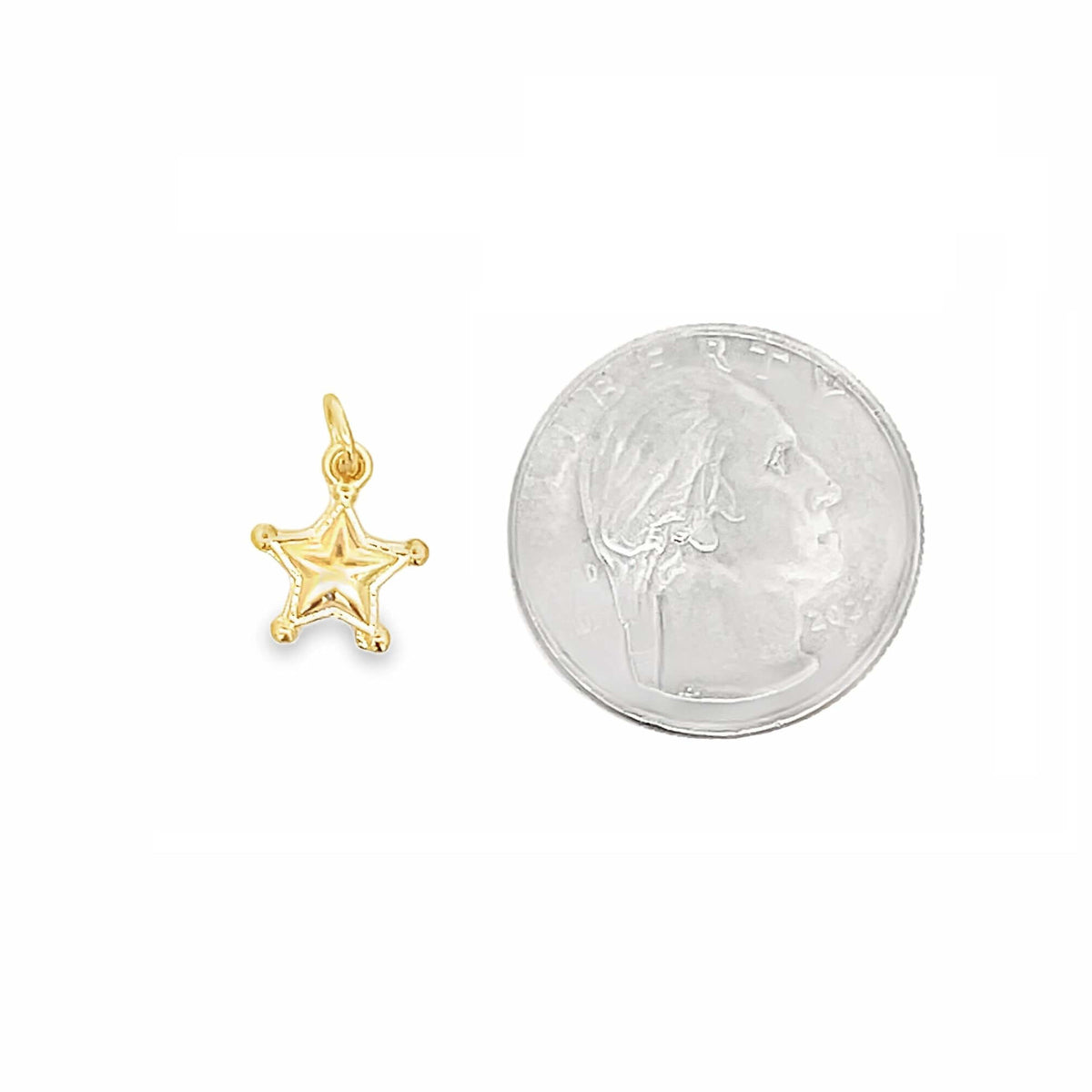 A small gold star charm rests beside a US quarter coin to show scale.