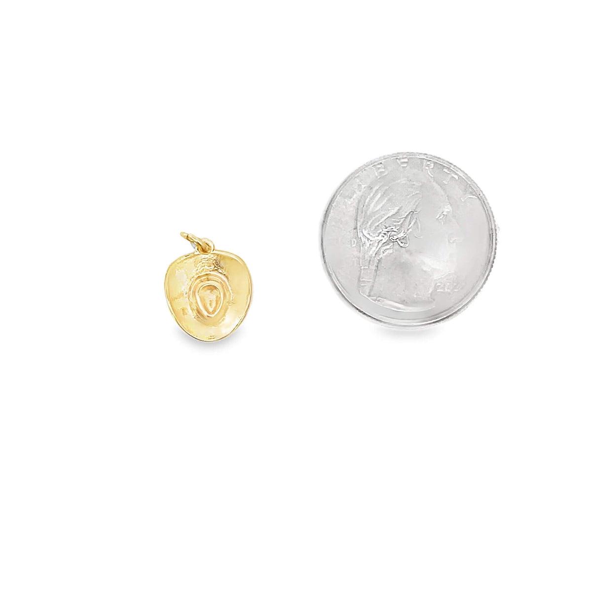 A small gold cowboy hat charm rests beside a US quarter coin for scale.