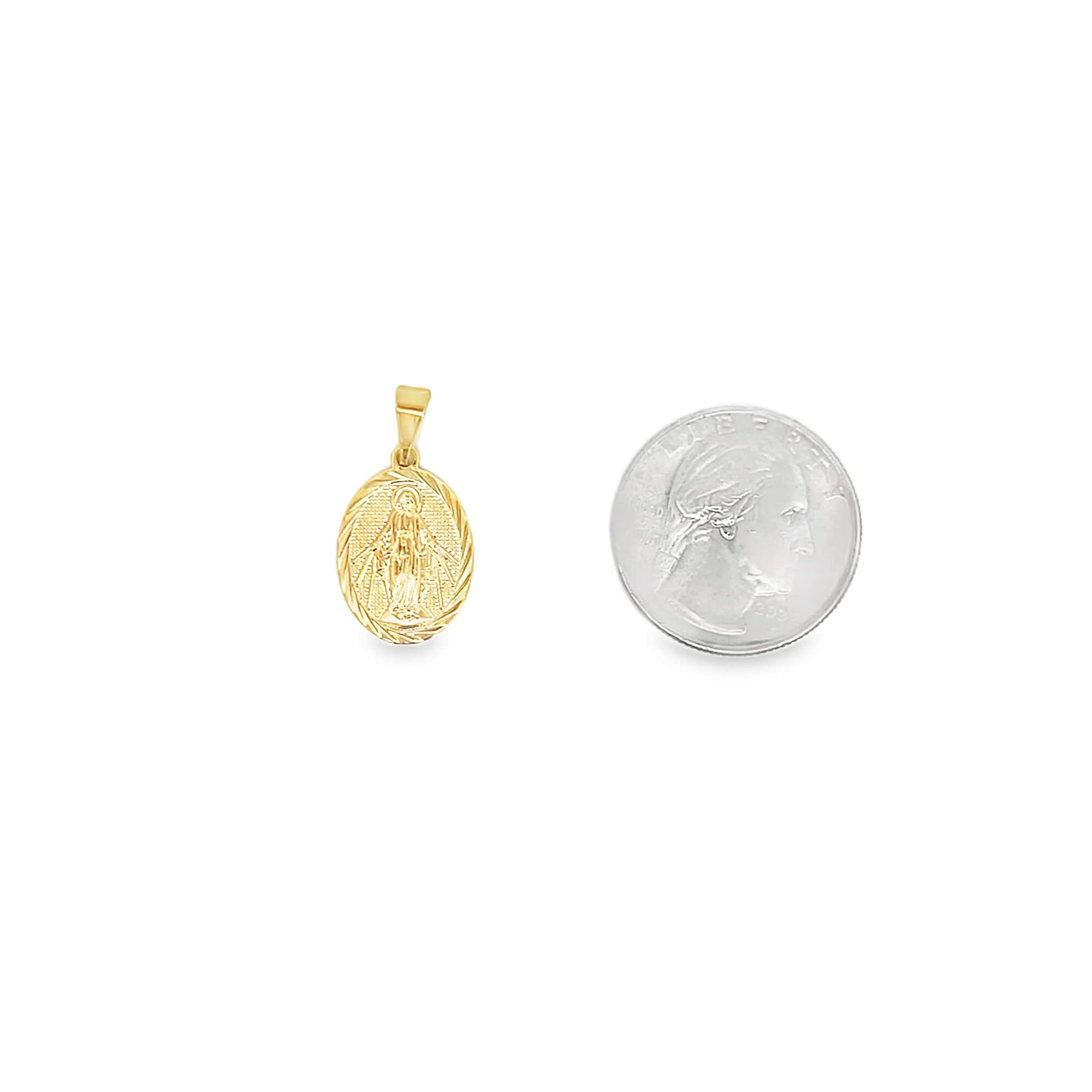 A gold oval Miraculous Medal pendant rests beside a US quarter for scale.