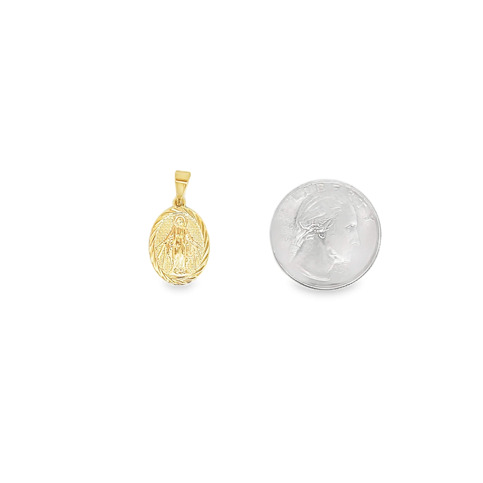 A gold oval Miraculous Medal pendant rests beside a US quarter for scale.