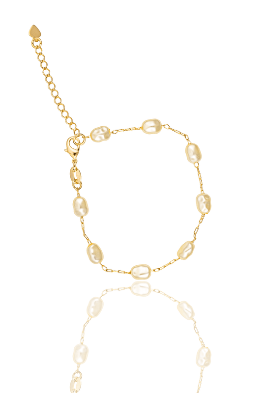 A delicate gold chain bracelet features irregularly shaped baroque pearls and an adjustable extender clasp against a clean white background.
