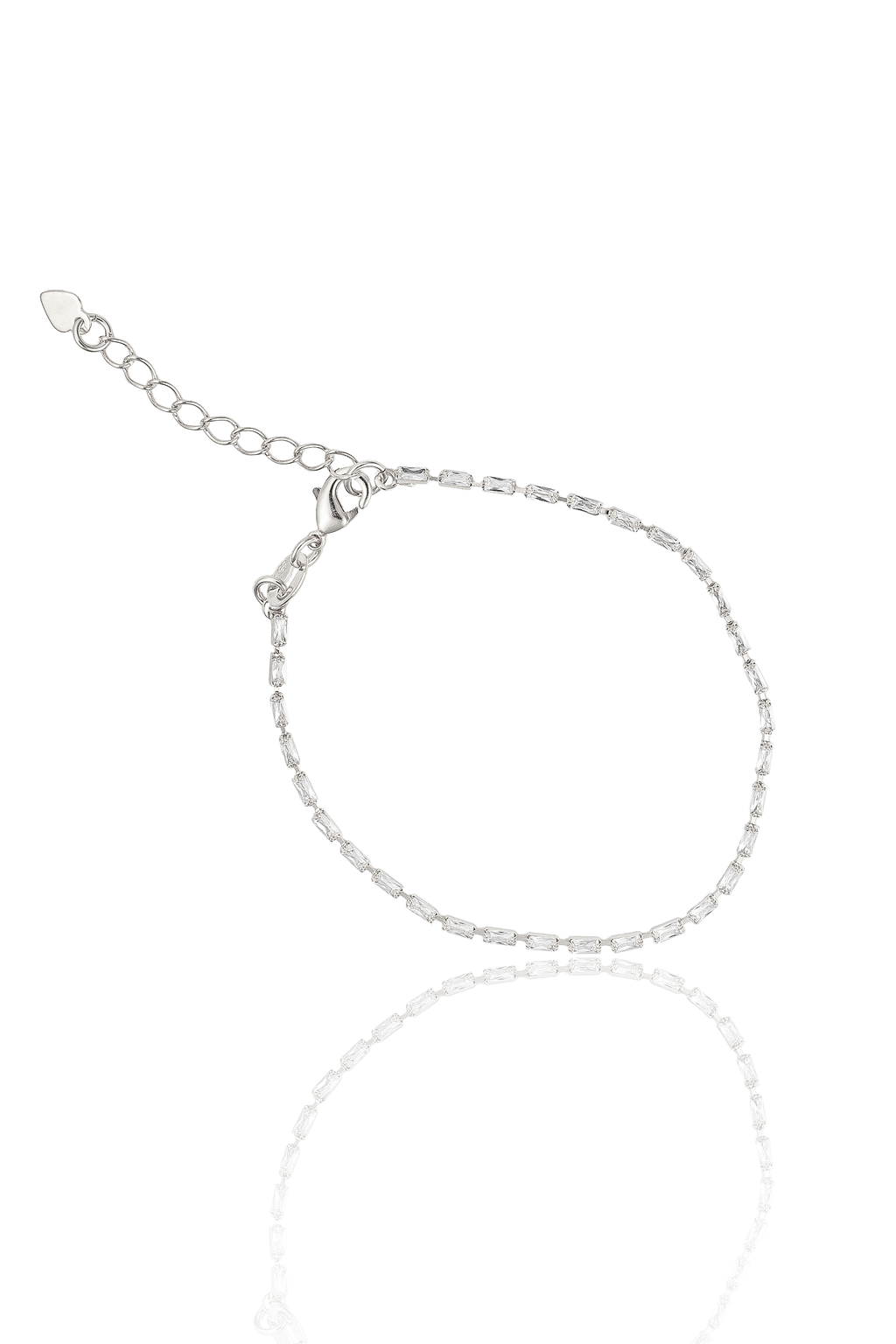 A delicate silver tennis bracelet encrusted with sparkling baguette-cut zirconia stones rests on a reflective white surface, showcasing its adjustable chain and lobster clasp.