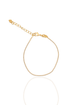 A delicate gold tennis bracelet sparkles against a white background, featuring a lobster clasp and an adjustable chain with a tiny heart charm.