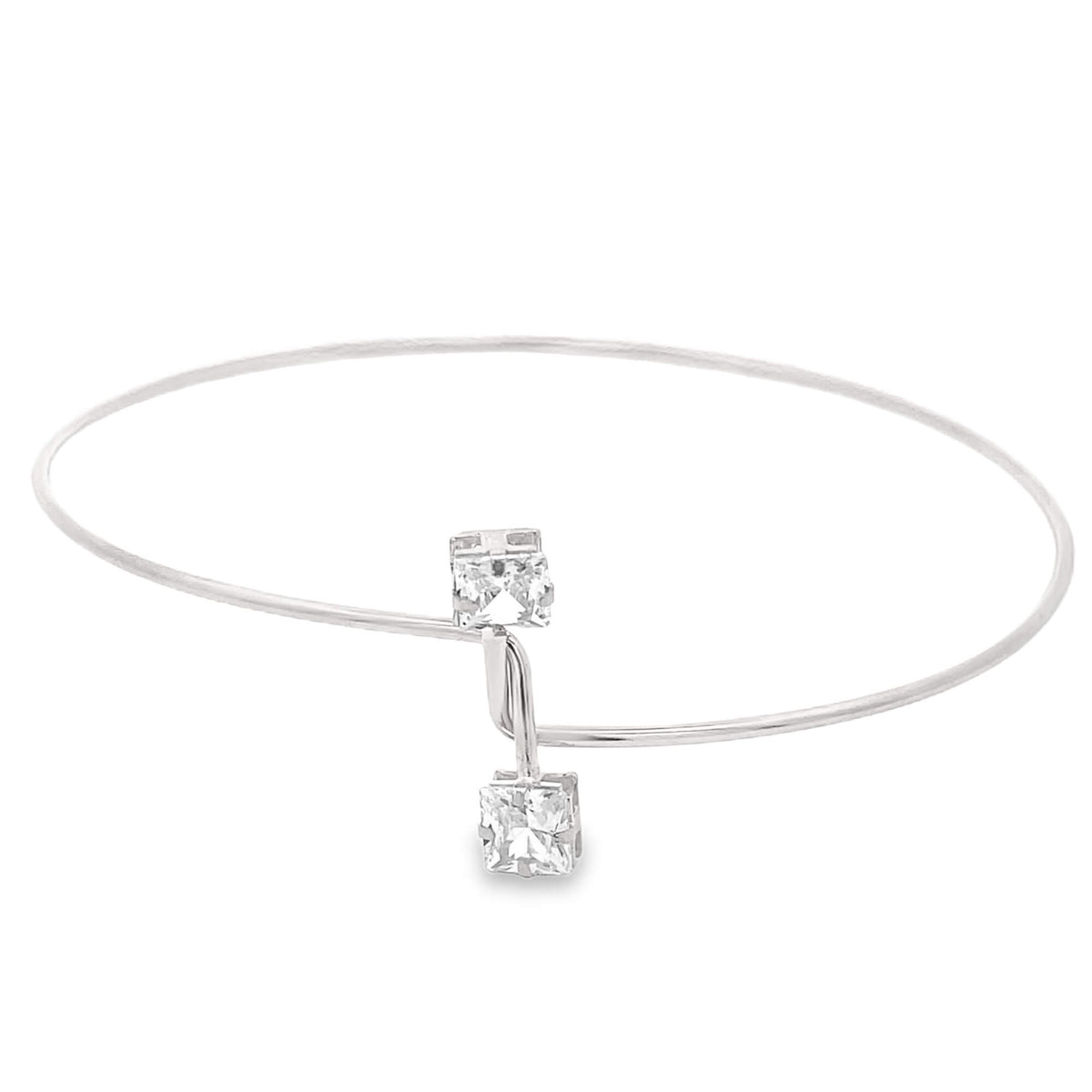 A sleek silver bangle bracelet features two sparkling princess-cut diamonds suspended in an overlapping open-ended design against a clean white background.