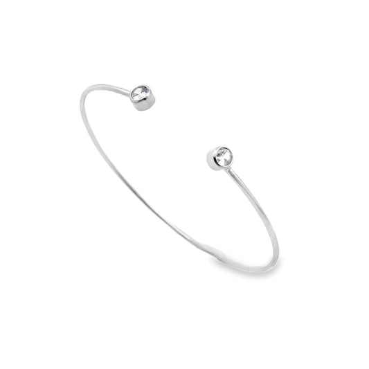 A sleek silver cuff bracelet sparkles with two cubic zirconia stones at each open end against a white background.