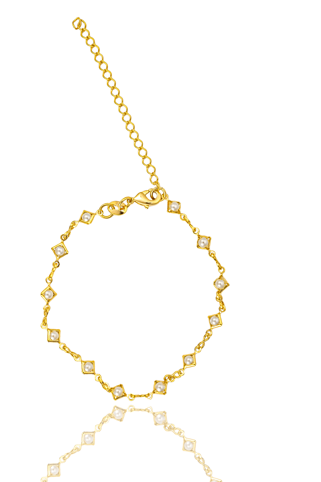 A delicate gold bracelet featuring alternating pearl accents and square links rests against a white background with a soft reflection.