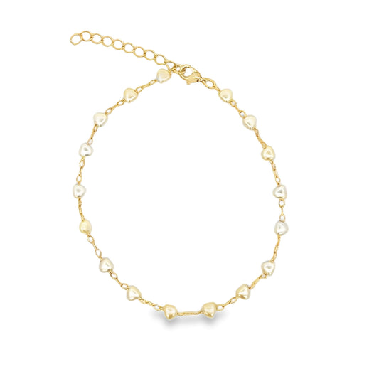 A delicate gold chain bracelet features alternating white and gold heart-shaped beads against a clean white background.