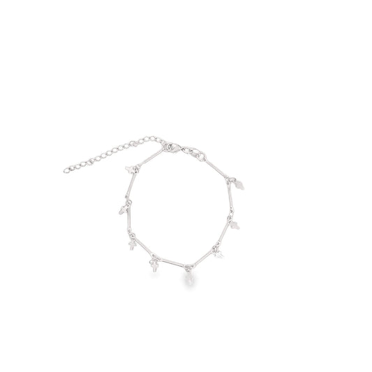 A delicate silver charm bracelet featuring multiple tiny cross charms dangles against a plain white background.