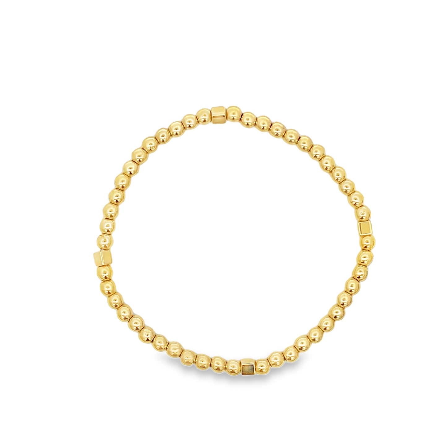 A gold beaded stretch bracelet rests in a circle on a white background.