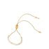 A gold adjustable slider bracelet sparkles with a curved line of round cubic zirconia stones.