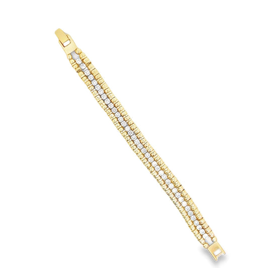 A polished gold and diamond tennis bracelet glistens diagonally against a clean white background.