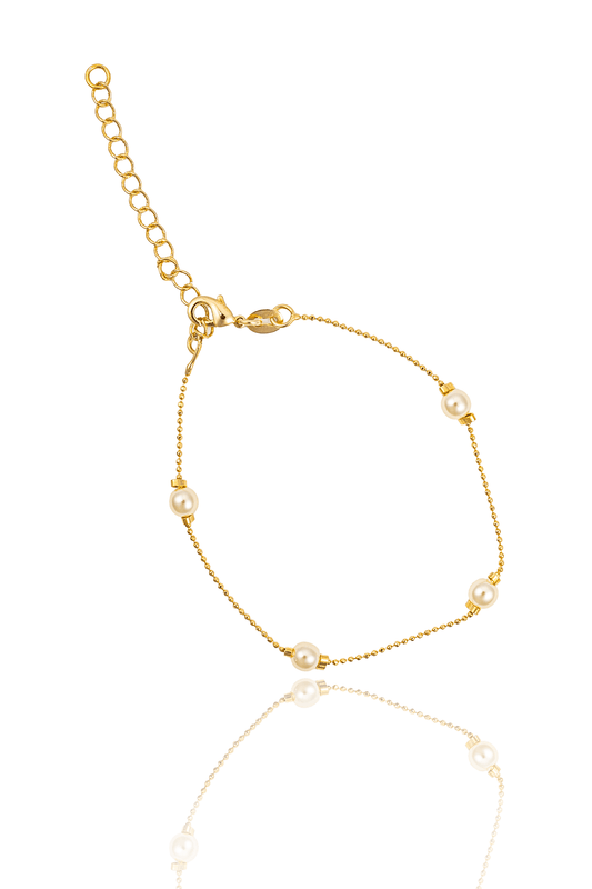 A delicate gold chain bracelet features interspersed pearls and an adjustable extension chain against a white background.