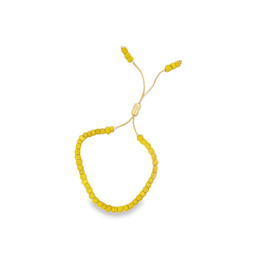 A yellow beaded adjustable bolo bracelet rests against a clean white background.
