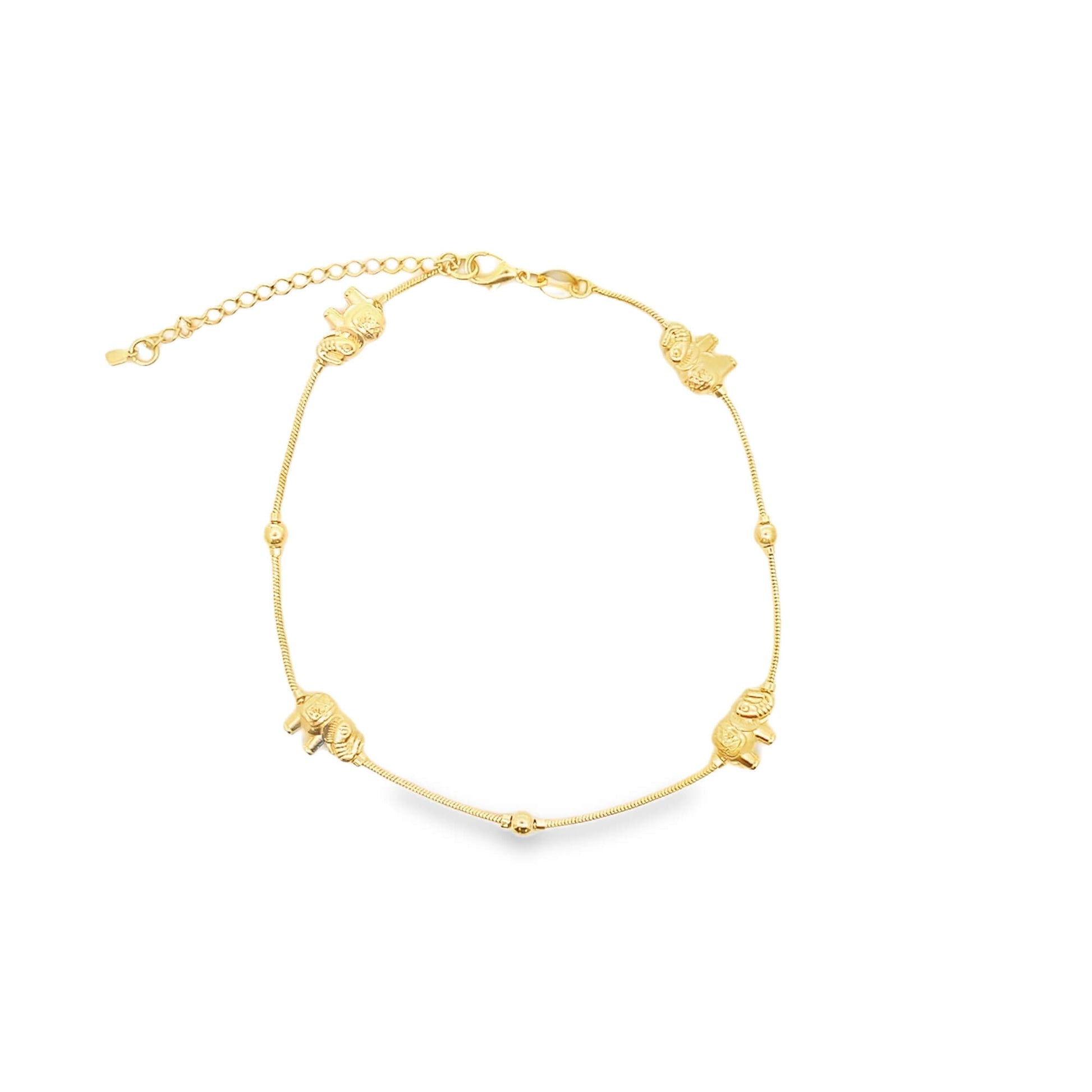 A delicate gold anklet features alternating spherical beads and miniature elephant charms along its chain.