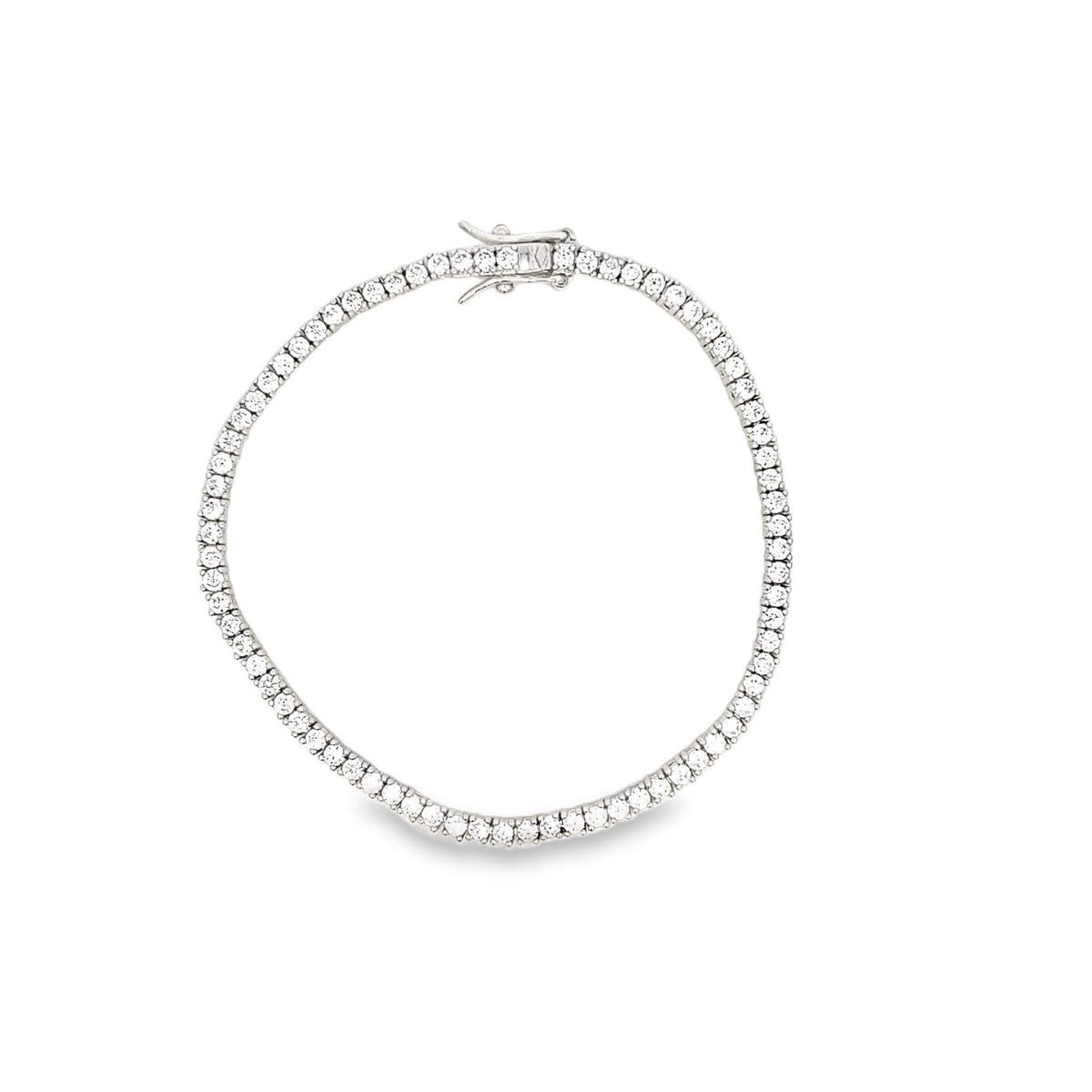 A sparkling diamond tennis bracelet with a secure clasp rests in a circle on a plain white background.