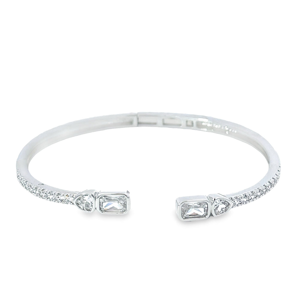 A shimmering silver cuff bracelet features sparkling pave diamonds and striking emerald-cut and teardrop stones at the open ends.