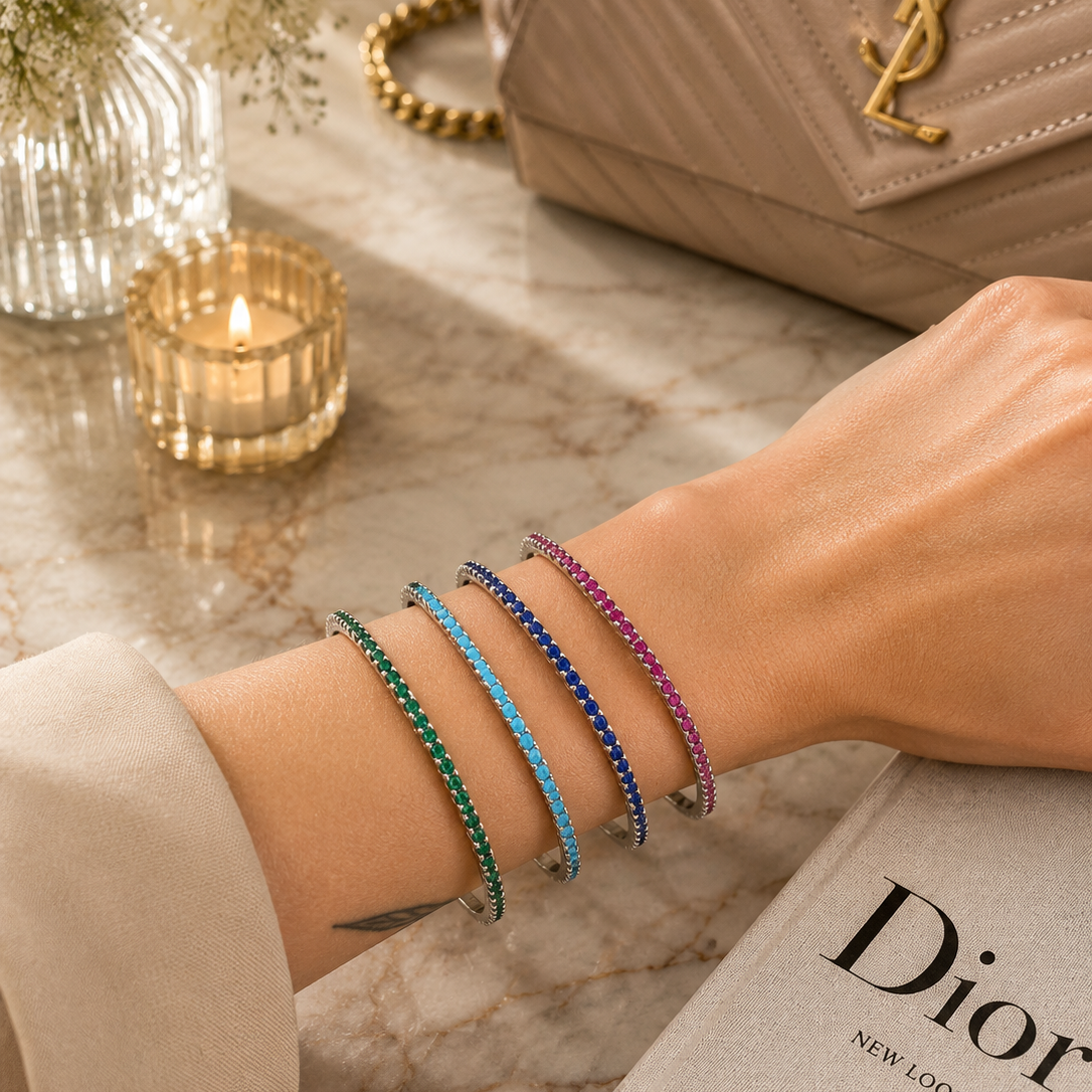 Elegant slim tennis bangle bracelet with sparkling colored CZ stones. Stackable minimalist design available in multiple color options for everyday luxury styling.