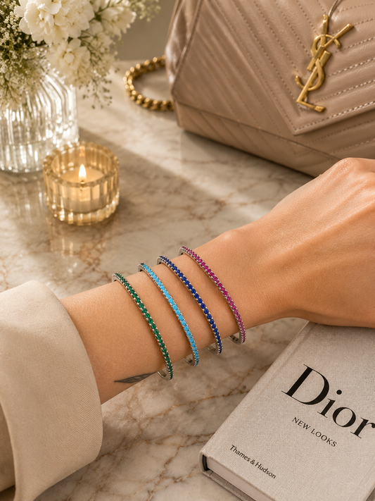 Elegant slim tennis bangle bracelet with sparkling colored CZ stones. Stackable minimalist design available in multiple color options for everyday luxury styling.