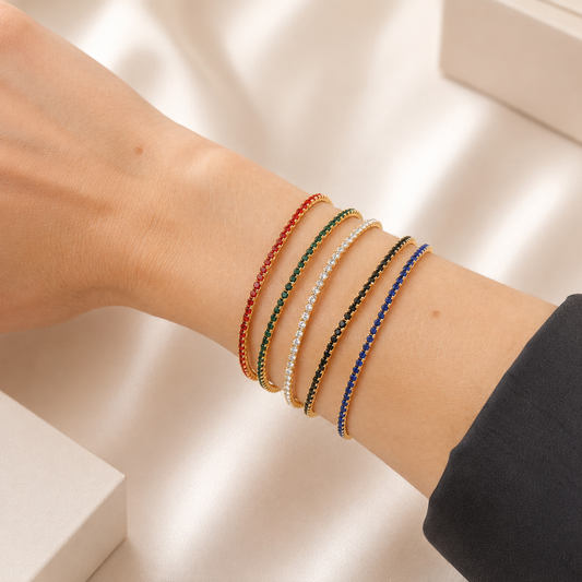 Elegant stretch tennis bracelet featuring sparkling colored CZ stones and a flexible elastic design for effortless wear. Perfect for stacking or wearing alone. Available in multiple vibrant colors including sapphire blue, emerald green, ruby red, black, and clear.