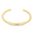 A minimalist polished gold cuff bracelet rests against a clean white background.