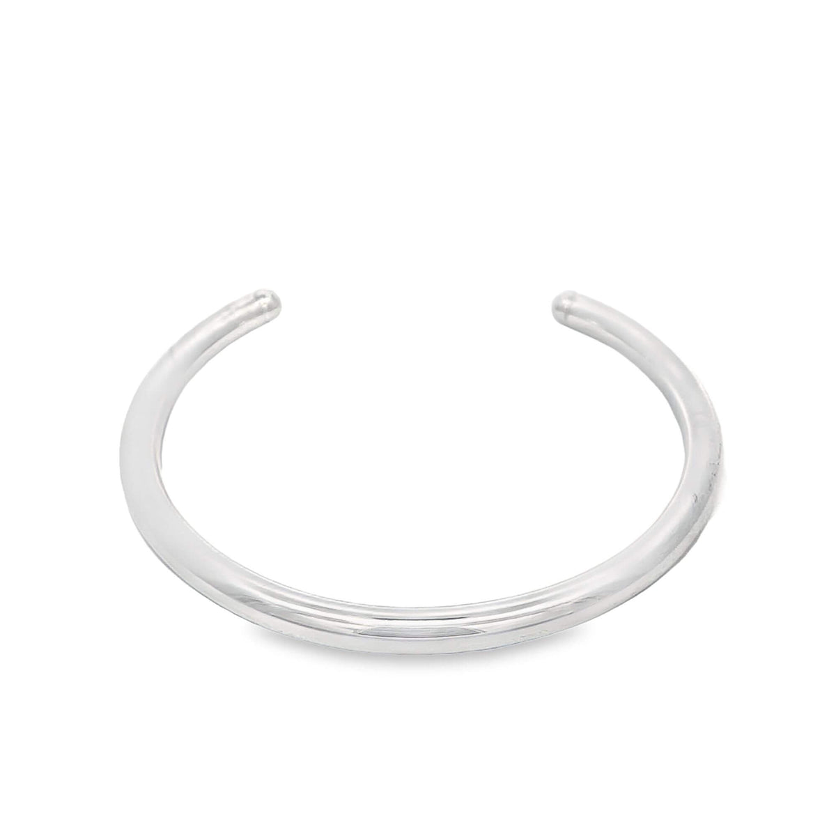 A sleek, polished silver cuff bracelet rests against a clean white background.