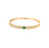 A gold pave-set crystal bangle bracelet features a vibrant emerald-cut green gemstone centered in the band.