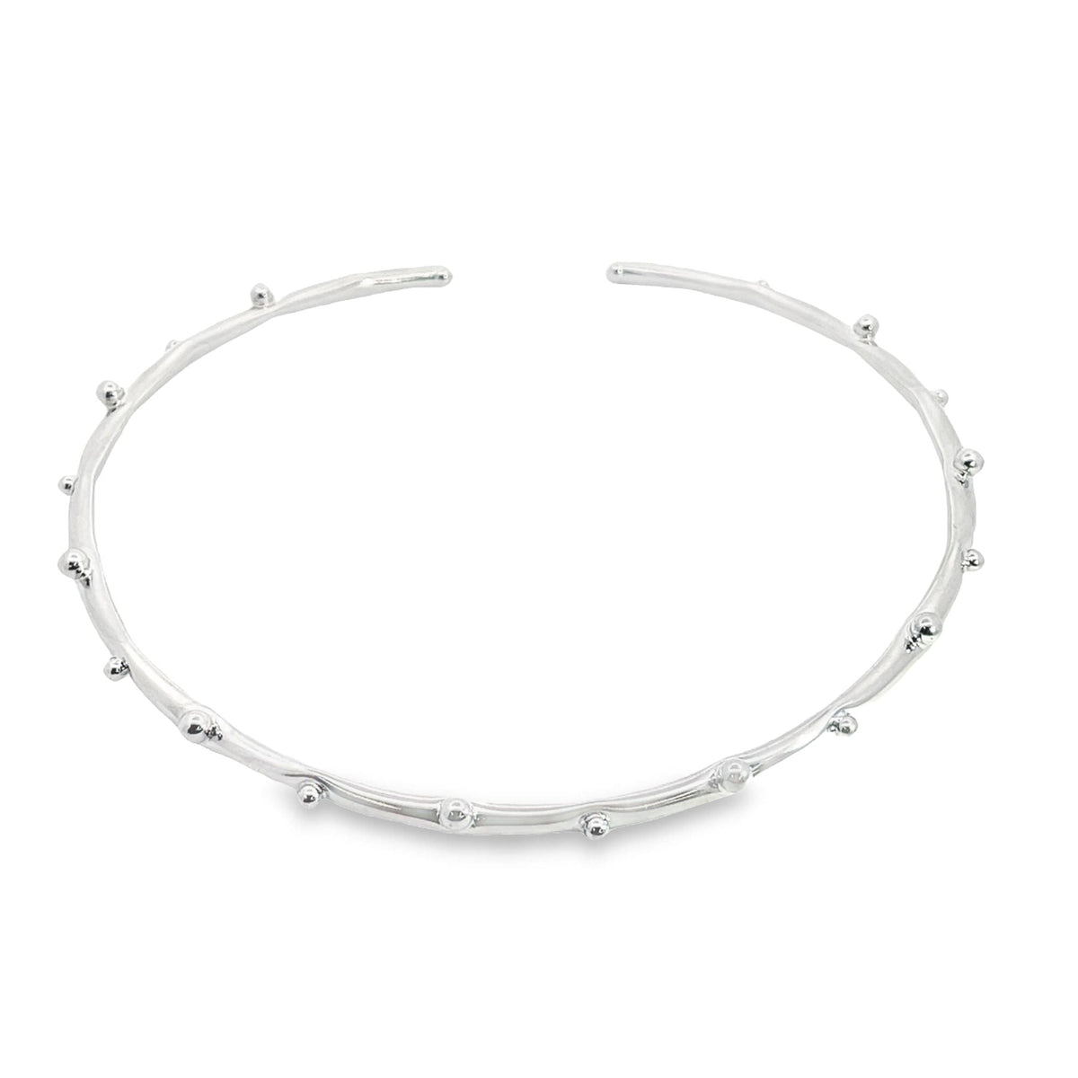 A sleek silver cuff bracelet features delicate, bead-like accents along its curved band against a clean white background.