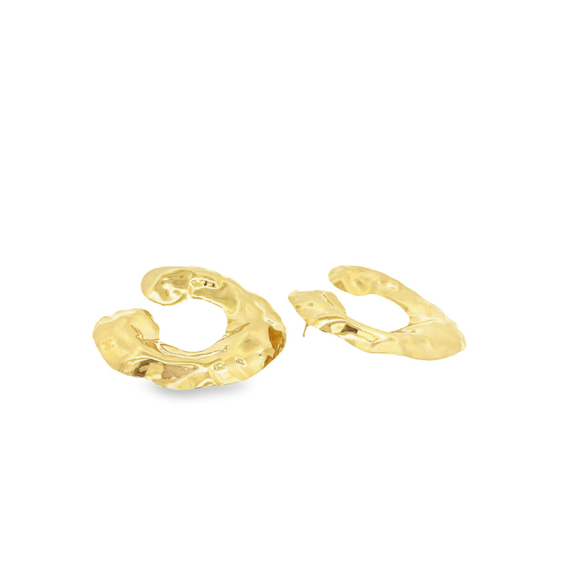 A pair of gold abstract textured hoop earrings rests against a white background.