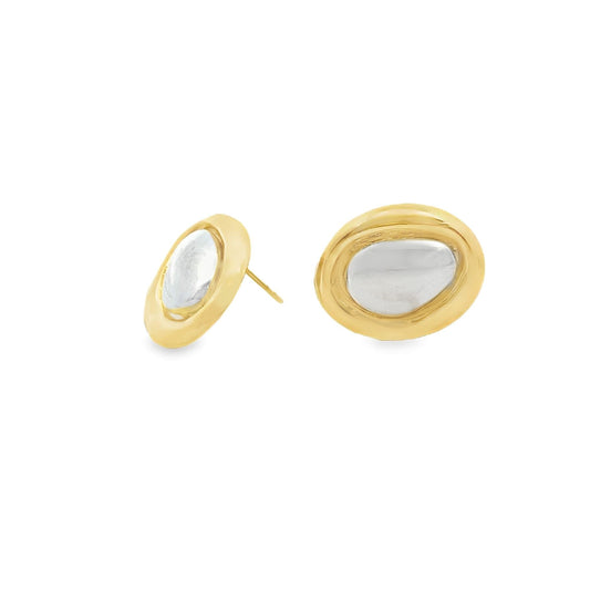 A pair of gold oval stud earrings features a shiny silver center stone against a clean white background.