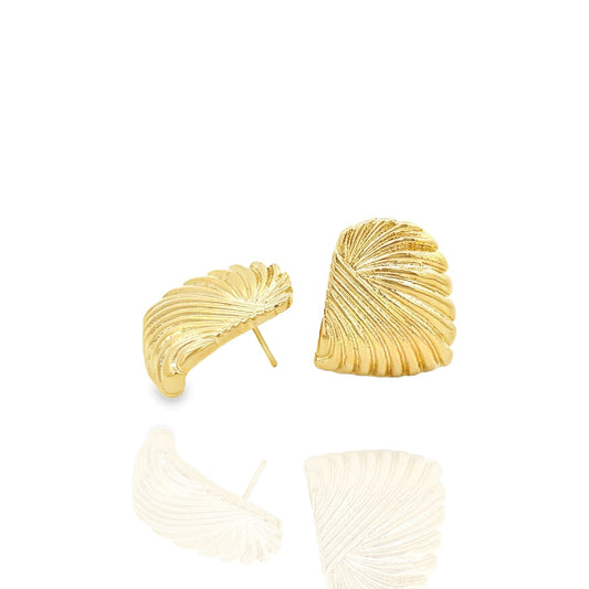 A pair of textured gold shell-shaped stud earrings rests against a white background with soft reflections beneath them.