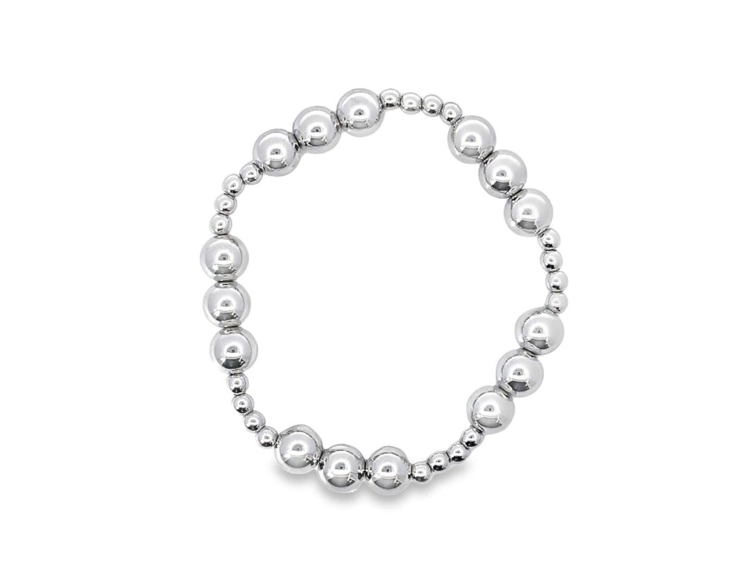 A sleek silver beaded bracelet displays a gradient of assorted metallic ball sizes arranged in a circular design against a plain white background.