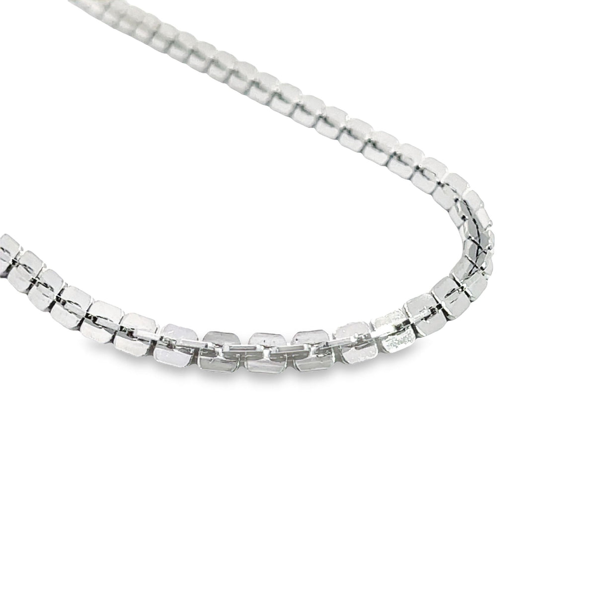 A gleaming silver tennis necklace curves gracefully against a clean white background.