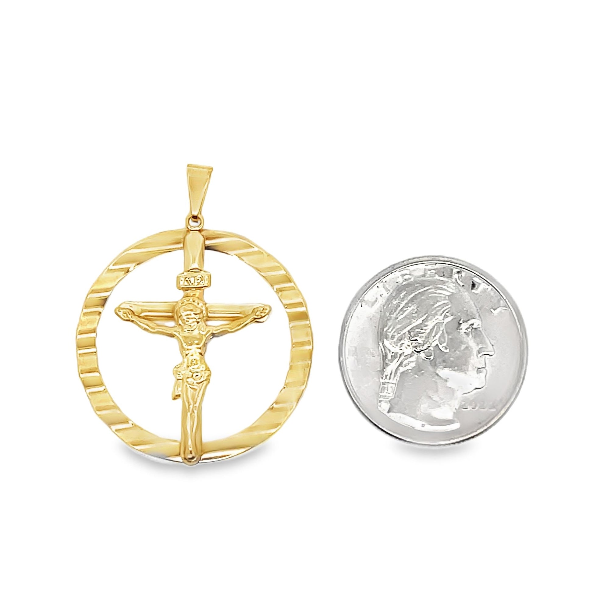 A gold crucifix pendant rests next to a US quarter coin to show its scale.
