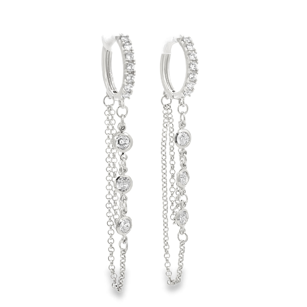 A pair of shimmering diamond huggie hoop earrings featuring delicate dangling chains against a clean white background.
