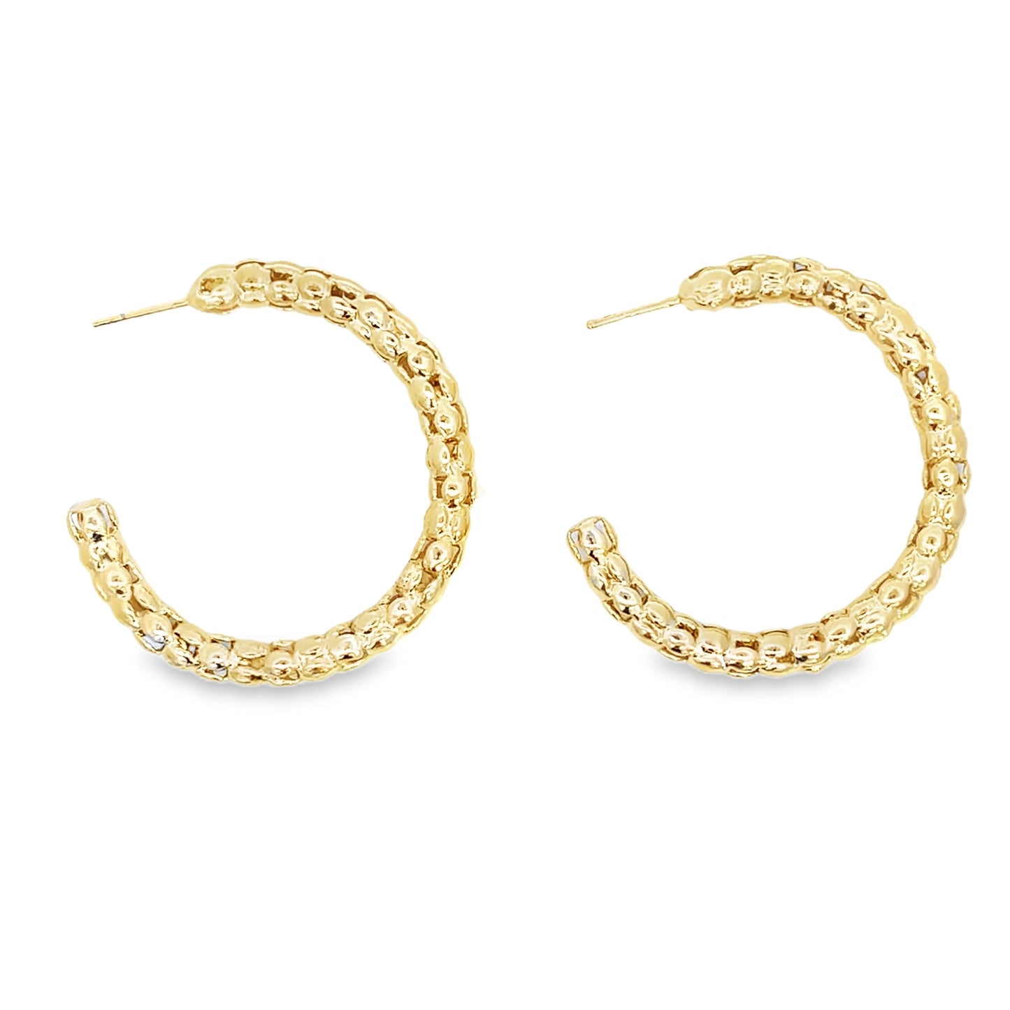 A pair of textured gold hoop earrings displays a beaded design against a white background.