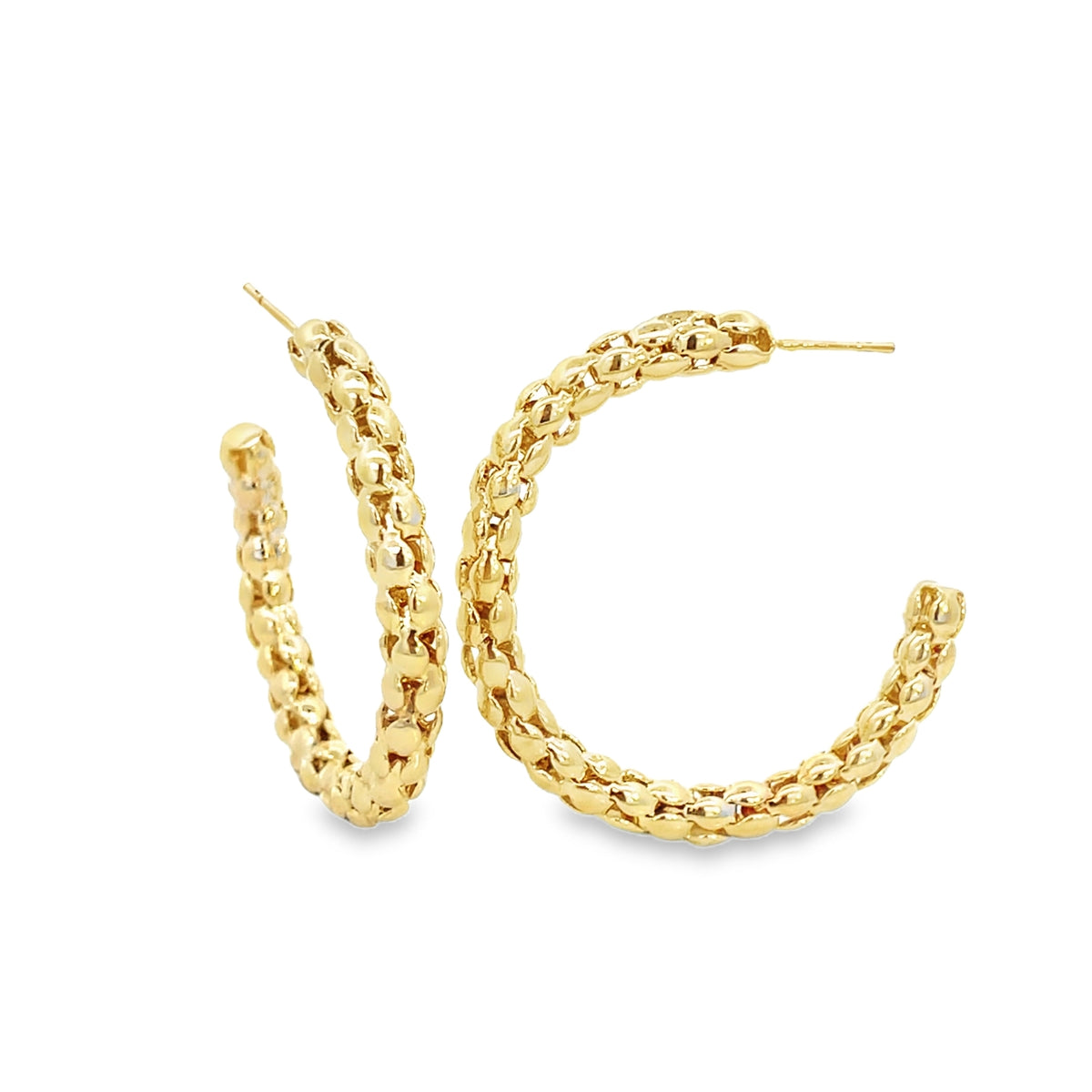 A pair of textured gold hoop earrings displays a detailed, beaded design against a white background.