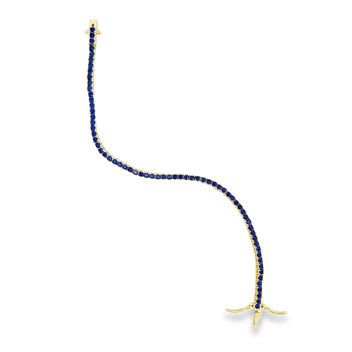 A graceful gold tennis bracelet sparkles with a continuous line of vibrant blue sapphires against a clean white background.