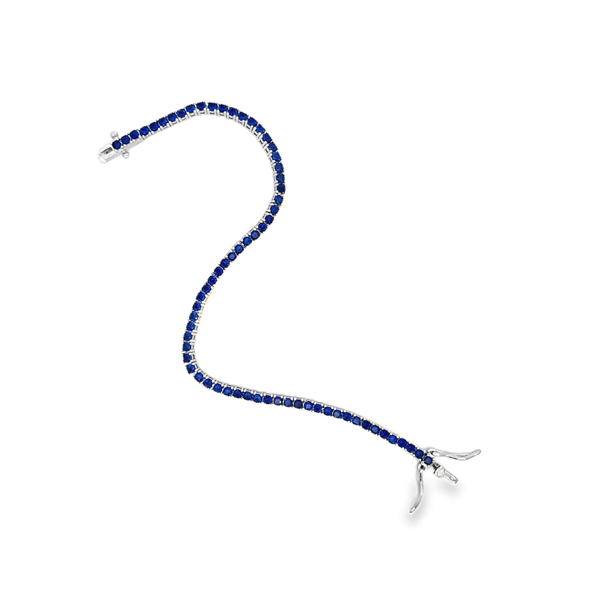 A delicate white gold tennis bracelet features a continuous line of vibrant blue sapphires against a plain white background.