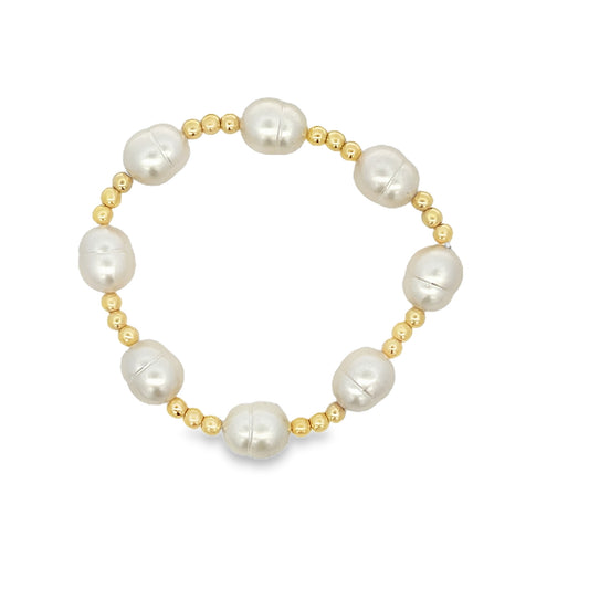 A handmade beaded bracelet features alternating freshwater baroque pearls and polished gold beads against a clean white background.