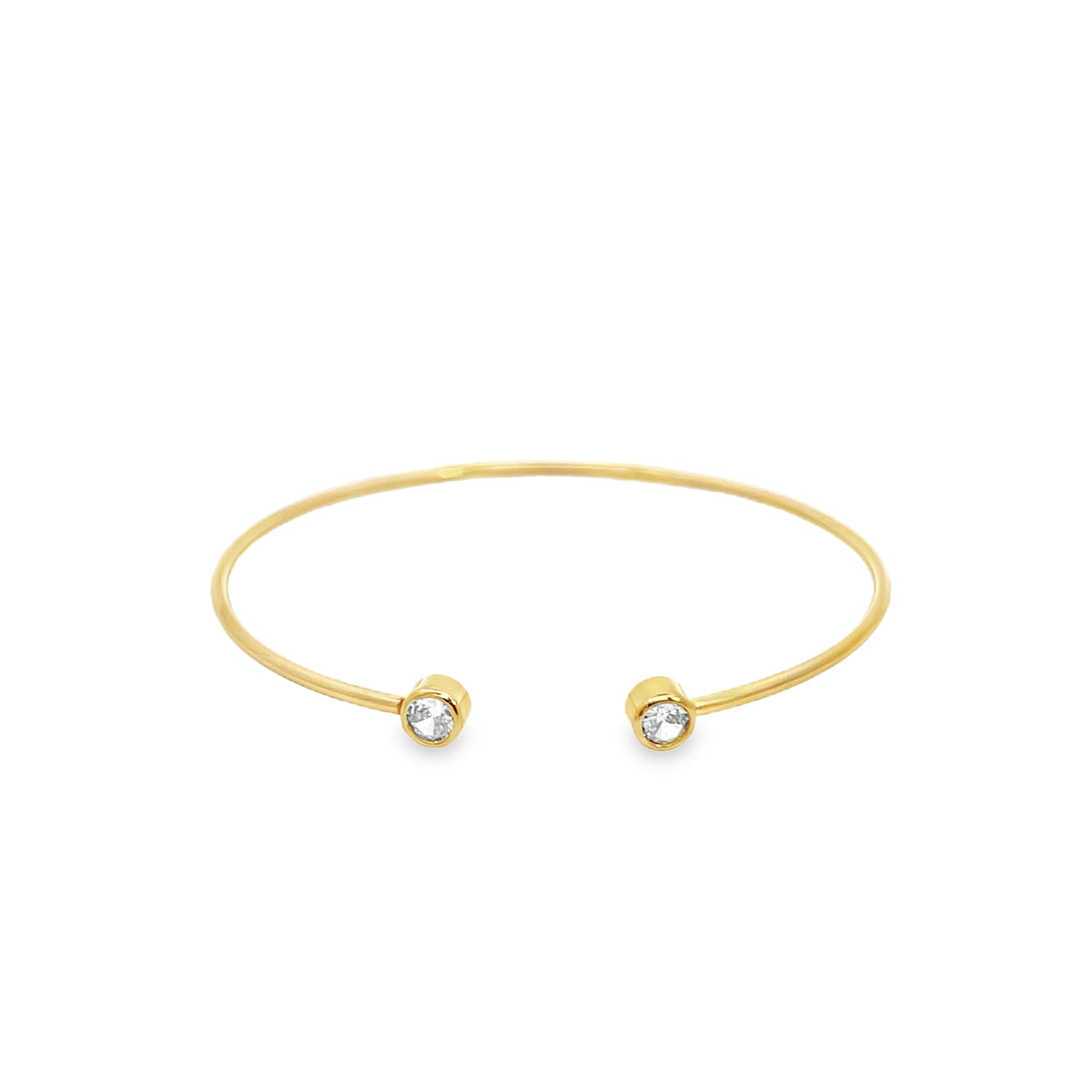 A sleek gold cuff bracelet sparkles with two bezel-set diamond ends against a clean white background.