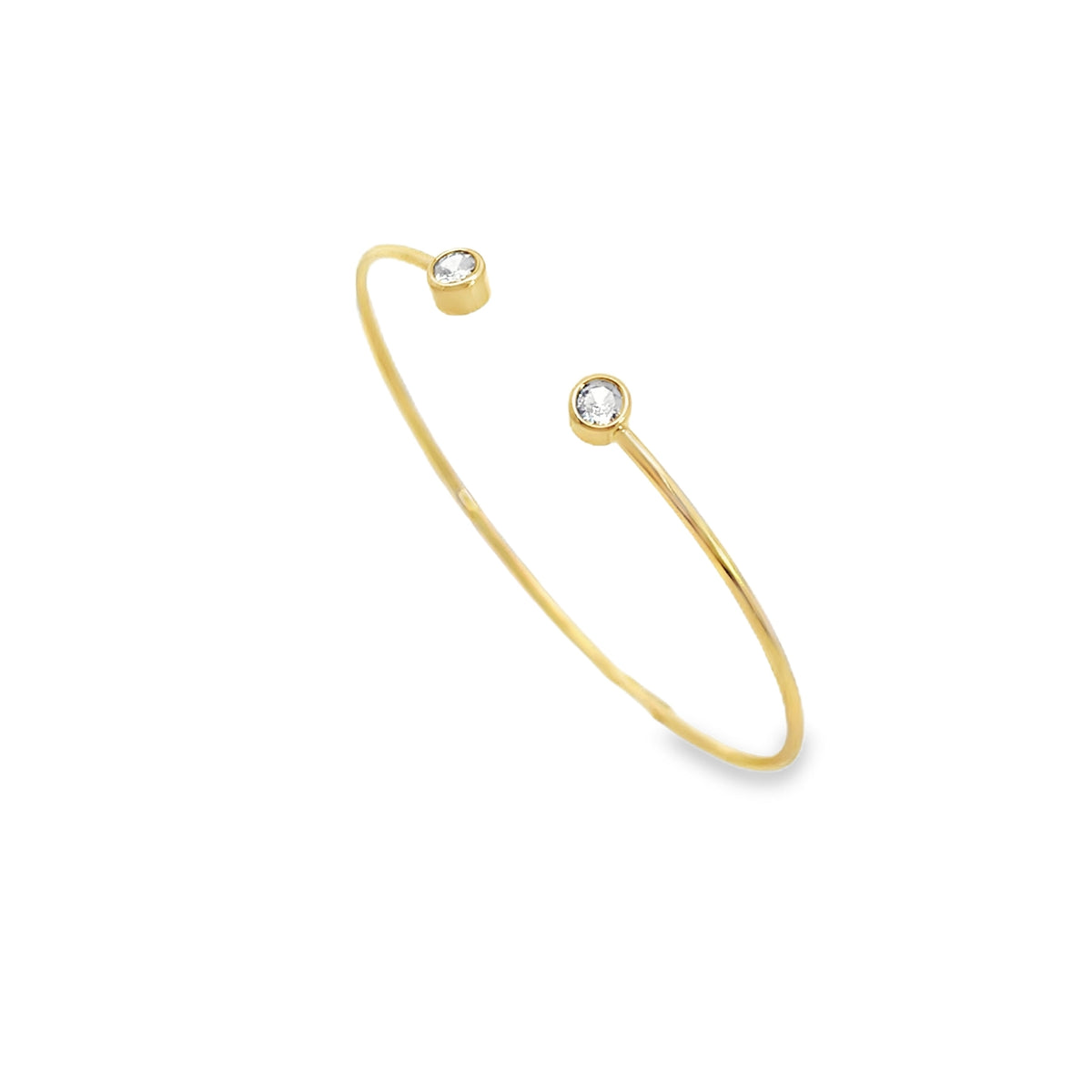 A delicate gold open cuff bracelet features sparkling bezel-set diamonds at each end against a clean white background.