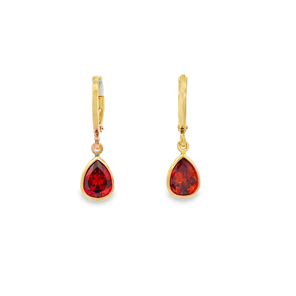 A pair of elegant gold hoop earrings dangles teardrop-shaped red gemstone pendants against a plain white background.