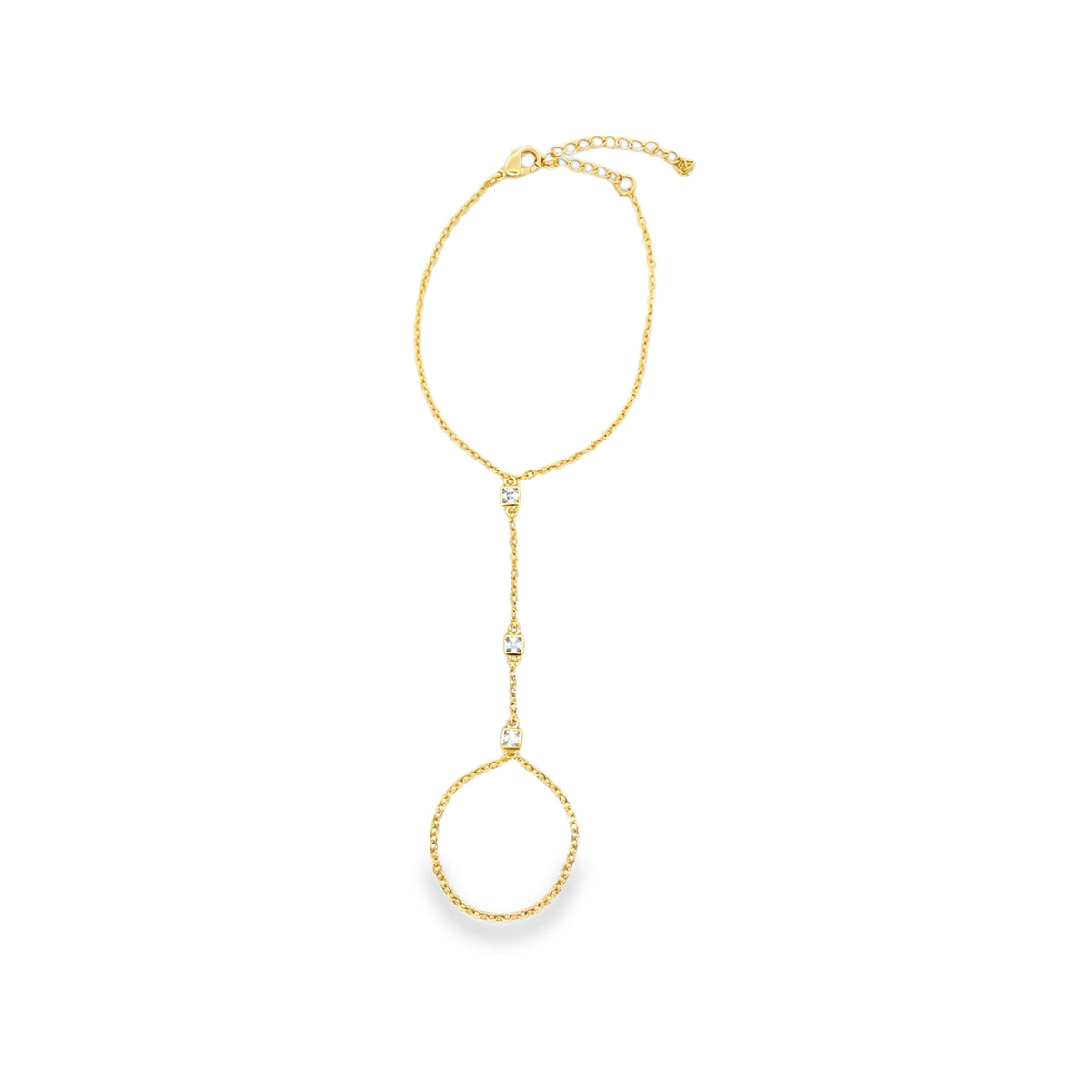 A delicate gold slave bracelet features a finger ring connected by a dainty chain adorned with sparkling diamond-like stones against a plain white background.