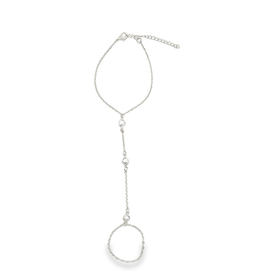 A delicate silver finger bracelet features a thin chain connecting a wrist loop to an integrated ring adorned with small beads.