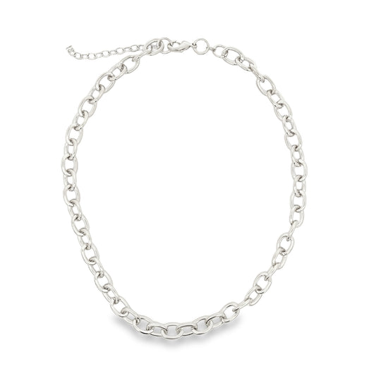 A glossy silver chain necklace rests in a circle against a white background.
