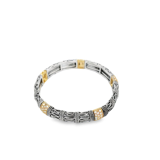 A detailed silver and gold Bali-style stretch bracelet features intricate filigree patterns and sparkling crystal accents on a plain white background.