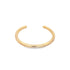 A minimalist gold cuff bracelet rests against a clean white background.
