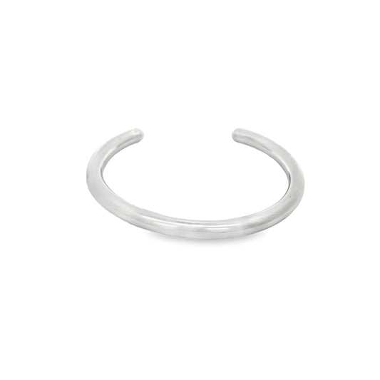 A sleek, minimalist silver cuff ring rests against a plain white background.