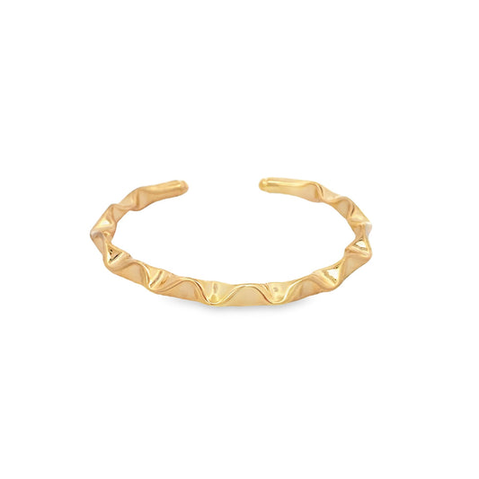 A polished gold cuff ring features a whimsical, rippled wave design against a clean white background.