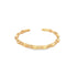 A polished gold cuff ring features a whimsical, rippled wave design against a clean white background.